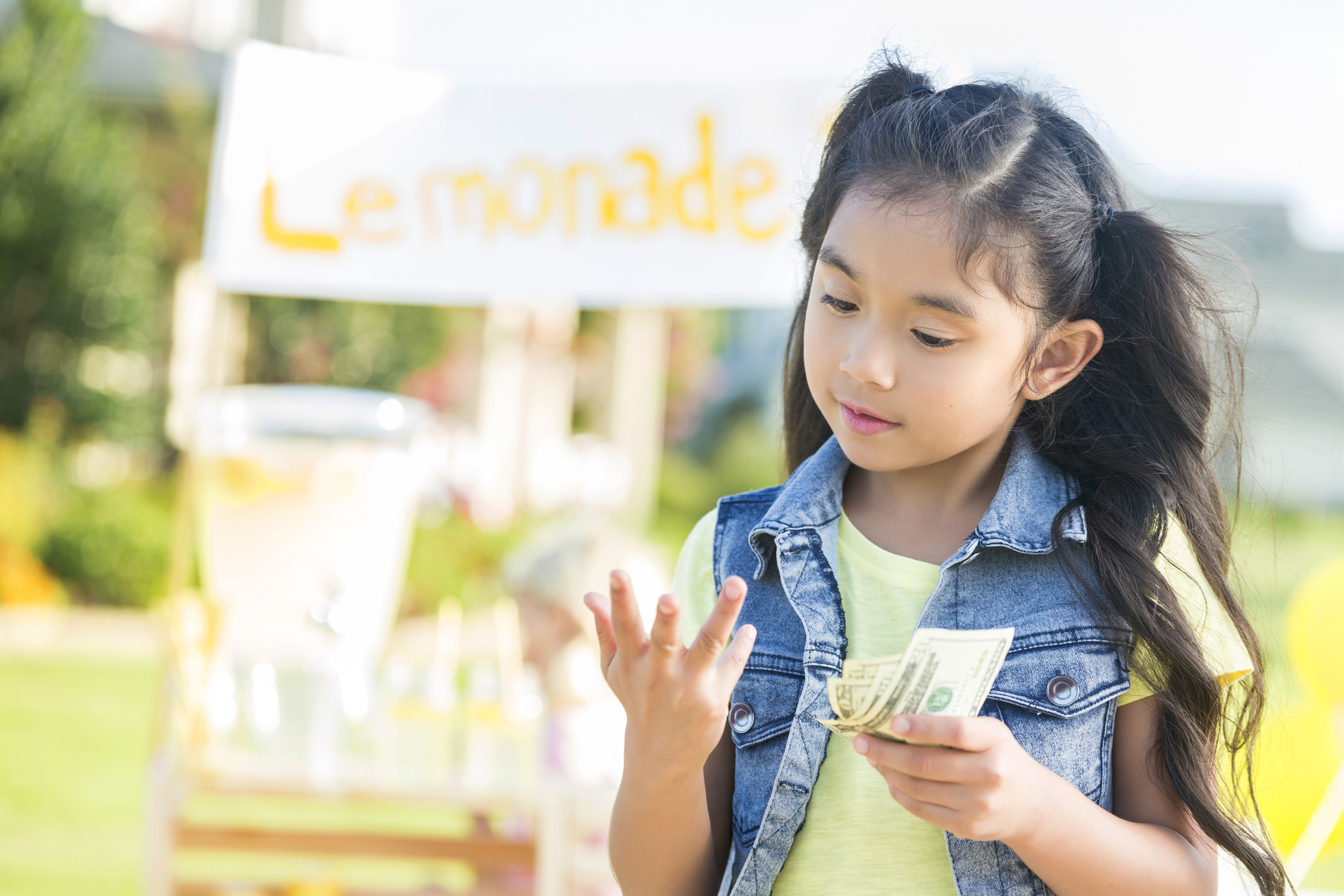 Little girl counting proceeds from sales