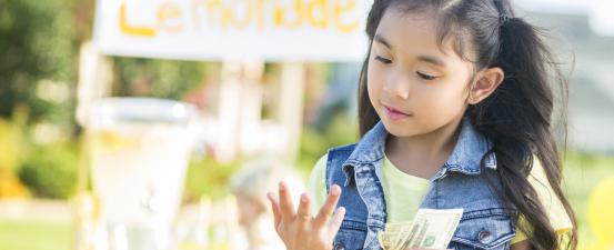 Little girl counting proceeds from sales